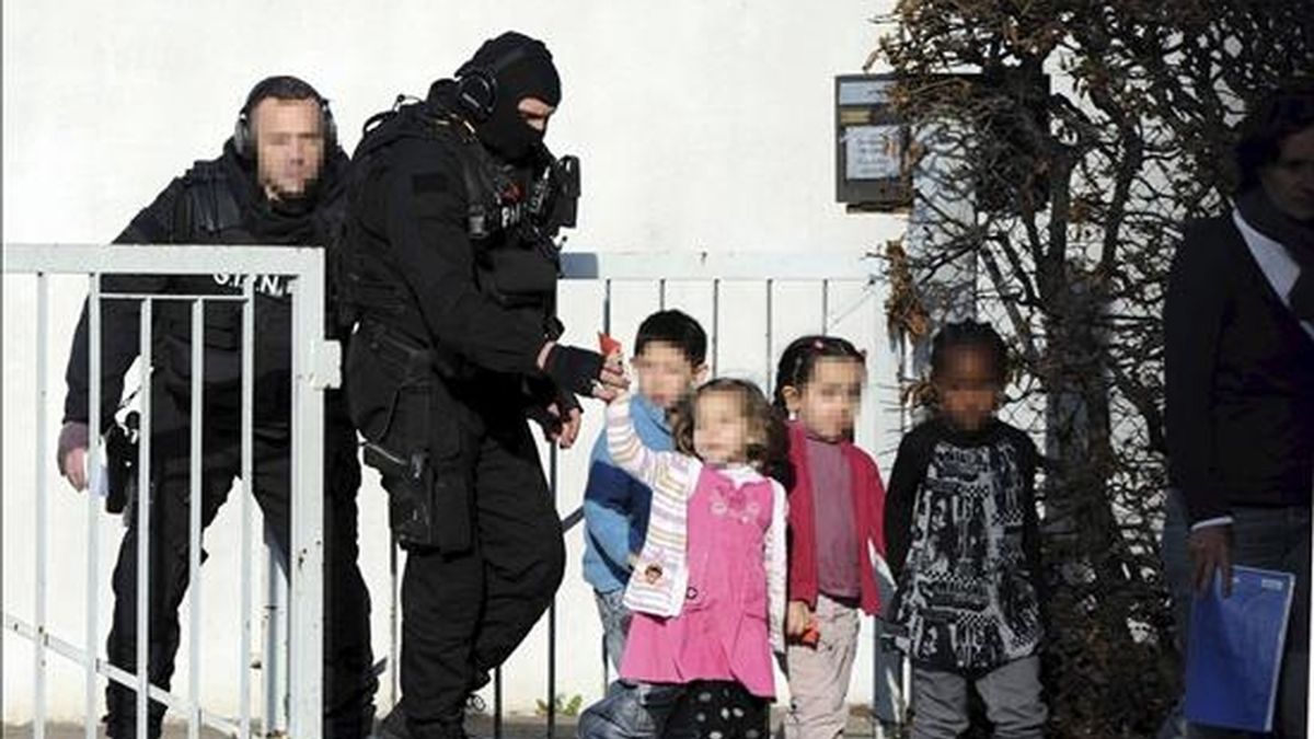 Efectivos de la policía francesa acompañan a varios niños de un colegio de Besançon, Francia, donde un adolescente con tendencias suicidas y armado con dos cuchillos ha secuestrado a veinte niños y una profesora. EFE