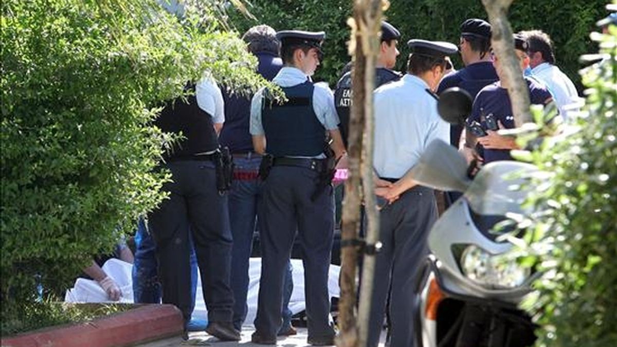 Policías de las brigadas antiterroristas griegas rodean el cuerpo del agente asesinado hoy en Atenas. EFE