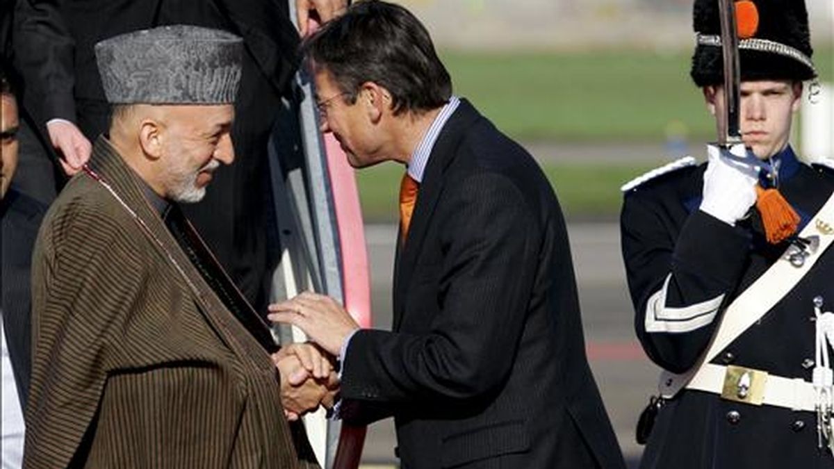 El presidente afgano, Hamid Karzai (izq.), es recibido por el ministro de Asuntos Exteriores holandés, Maxime Verhagen, a su llegada al aeropuerto de Rotterdam. EFE