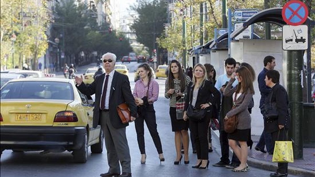 Unas personas intentan regresar a sus hogares en taxi en Atenas, Grecia, en un día de huelga. EFE/Archivo