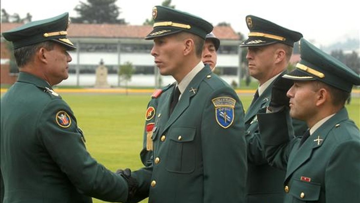 El ministro interino de Defensa y comandante de las Fuerzas Militares, el general Freddy Padilla de León (i), felicita a Juan Carlos Bermeo (2 i) durante la ceremonia de ascenso que se realizó en la escuela militar José María Córdova. EFE