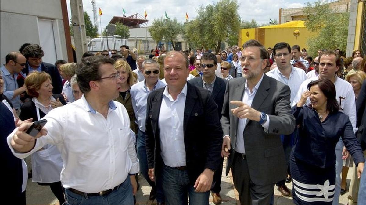 Foto facilitada por el Partido Popular (PP) de su presidente, Mariano Rajoy (d), acompañado por el candidato del partido a la Presidencia de la Junta de Extremadura, José Antonio Monago (2d), en una visita a la Feria del Jamón de Jerez de los Caballeros (Badajoz). EFE