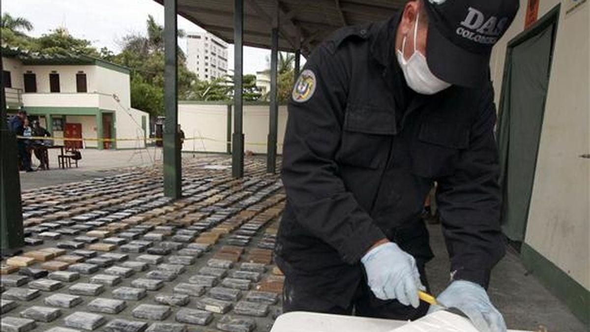 Un agente de la policia judicial inspecciona un paquete con cocaina luego de que miembros de Guardacostas de la Armada de Colombia realizaron un decomiso de más de una tonelada y media de cocaína. EFE
