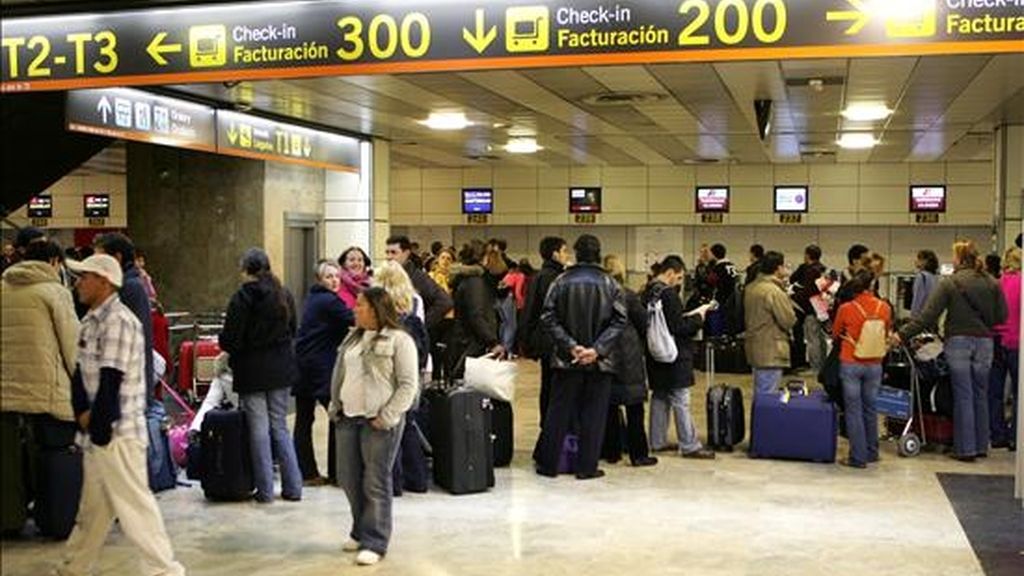 Decenas de personas hacen cola para facturar sus maletasen el madrileño aeropuerto de Barajas. EFE/Archivo Decenas de personas hacen cola para facturar sus maletasen el madrileño aeropuerto de Barajas. EFE/Archivo