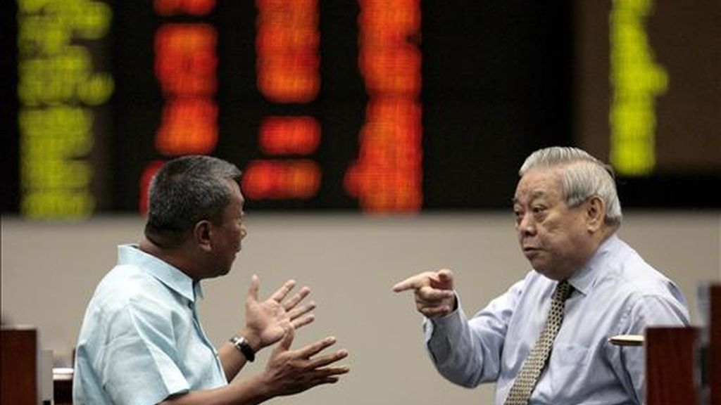 Dos corredores de bolsa filipinos conversan frente a un tablero electrónico con los índices de la Bolsa de Valores de Manila en el distrito financiero de Makati. EFE/Archivo Dos corredores de bolsa filipinos conversan frente a un tablero electrónico con los índices de la Bolsa de Valores de Manila en el distrito financiero de Makati. EFE/Archivo