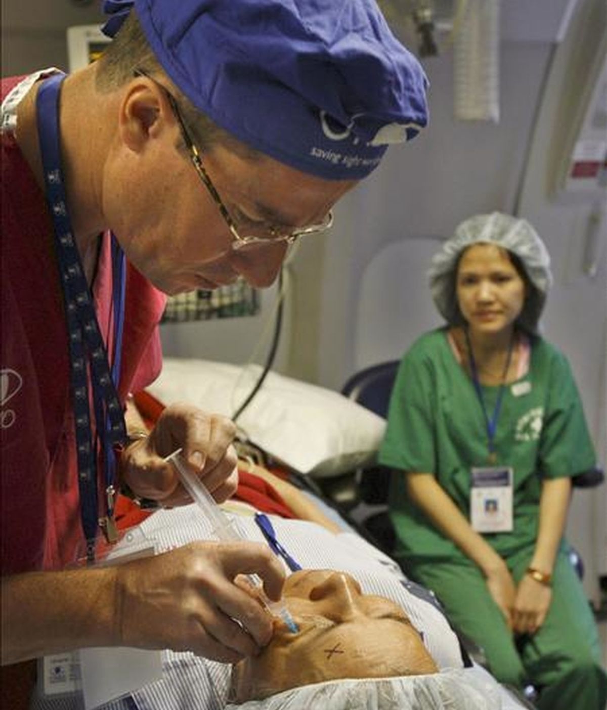 Un doctor prepara a un paciente para practicarle una operación ocular. EFE/Archivo