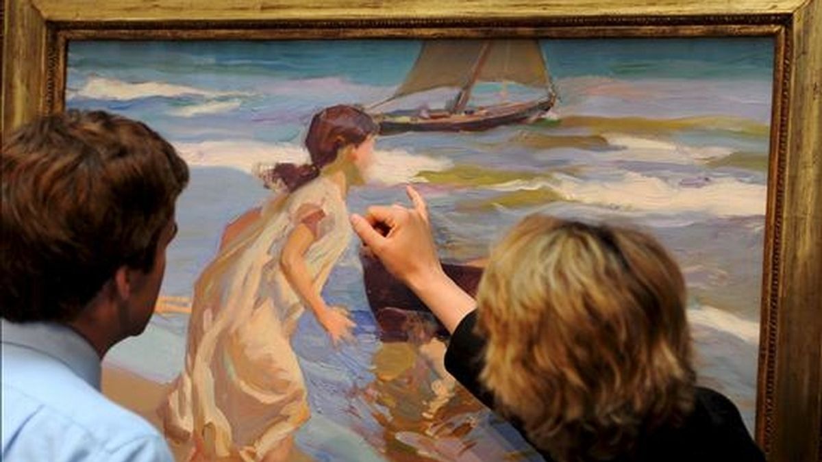 Unas personas observan el cuadro "Niña entrando en el baño", del pintor español Joaquín Sorolla, fechado en 1917 aunque acabado dos años antes, en la sede de Sotheby's en Londres (Reino Unido), el 29 de mayo pasado. EFE/Archivo