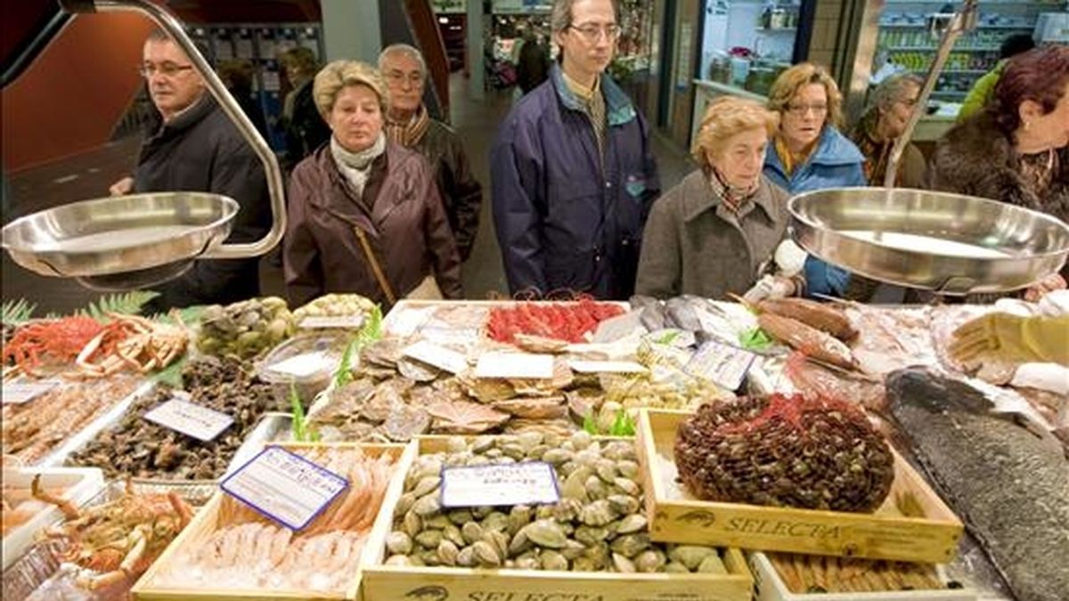 Un grupo de personas hacen cola ante una pescadería. EFE/Archivo