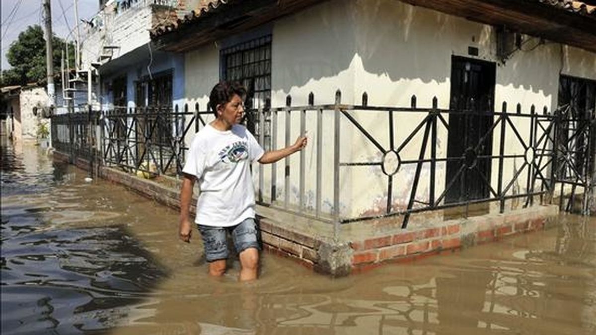 Una habitante camina este jueves por una calle de Juanchito, zona rural de Candelaria en el Valle del Cauca (Colombia), luego de que el río Cauca se desbordara e inundara este corregimiento. EFE