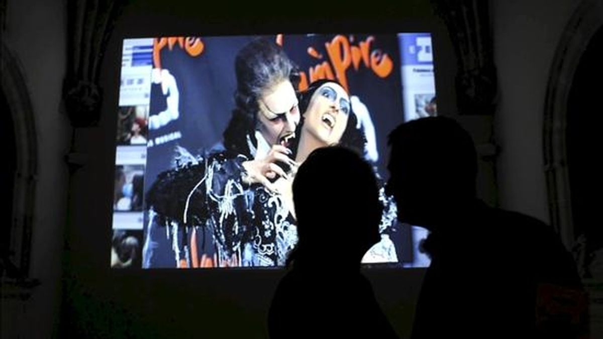 Dos personas se besan ante una de las imágenes que forman parte de "Besos", una producción de EFE Televisión con fotografías de los reporteros de la Agencia. EFE