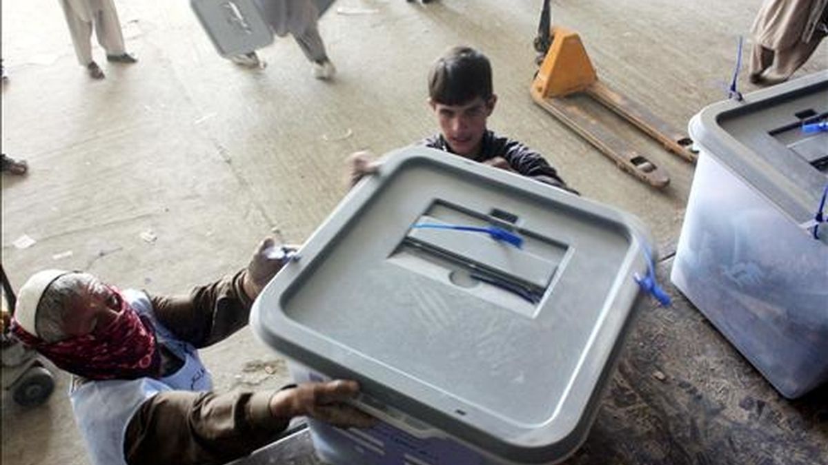 Dos trabajadores ordenan urnas electorales tras las elecciones parlamentarias en un depósito de la Comisión Electoral de Afganistán, en Kabul. EFE