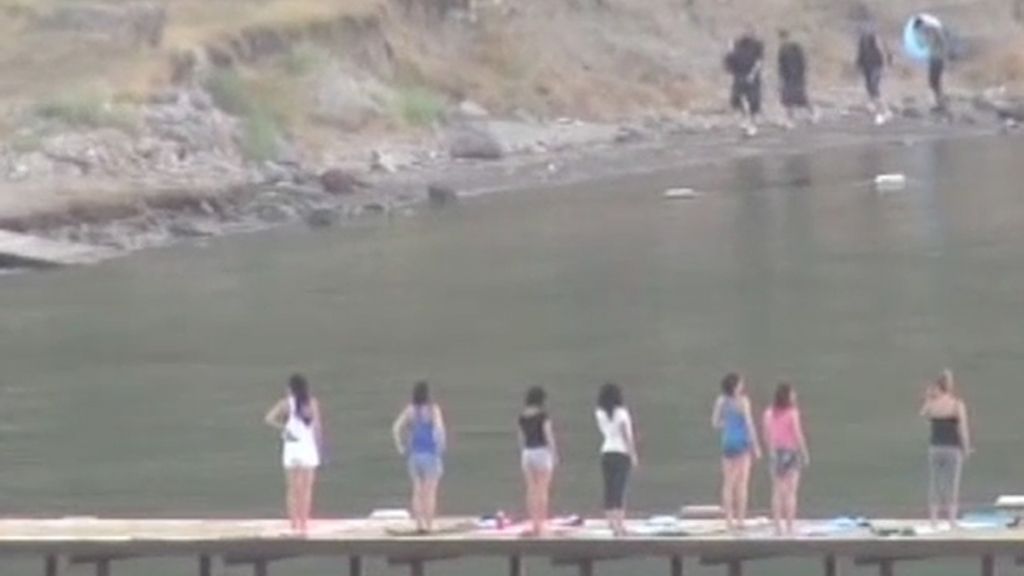 Yoga en una playa turca mientras llega un grupo de inmigrantes