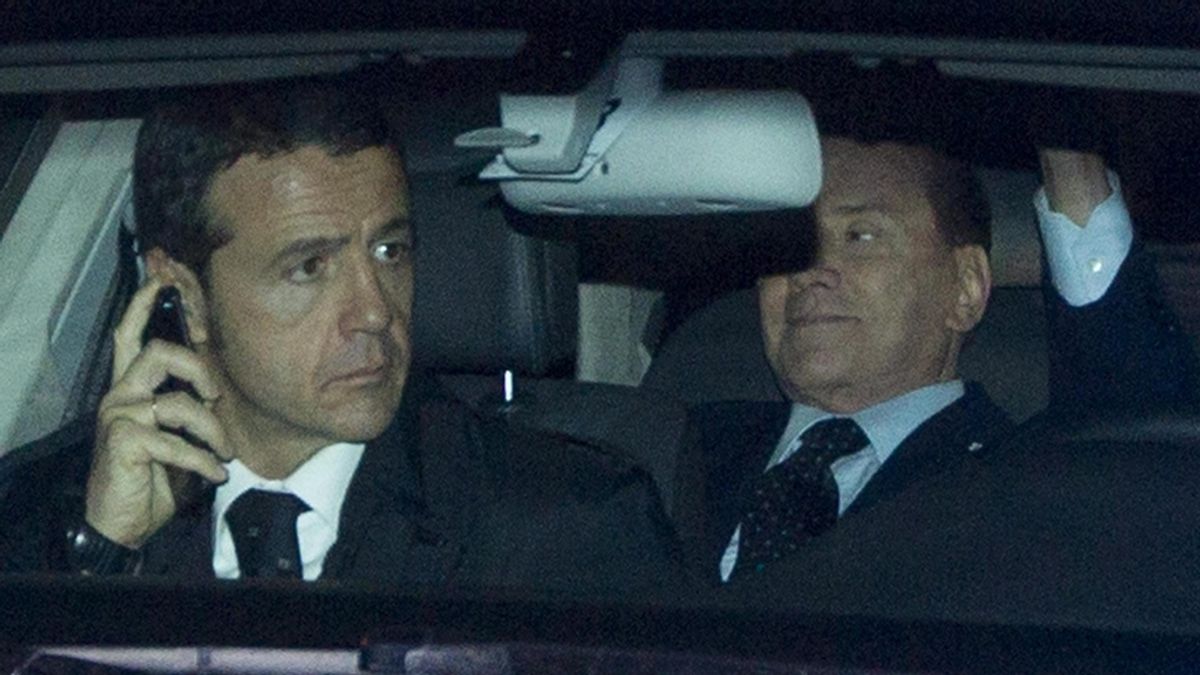 El primer ministro italiano Silvio Berlusconi saluda desde el interior del vehículo en el que se traslada al palacio presidencial, para presentar formalmente su dimisión al presidente de la república, Giorgio Napolitano, en Roma, Italia.