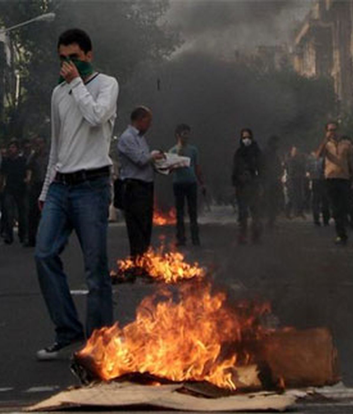 Un manifestante en medio del humo y el fuego provocado tras las protestas de la oposición en Teherán. Foto: EFE