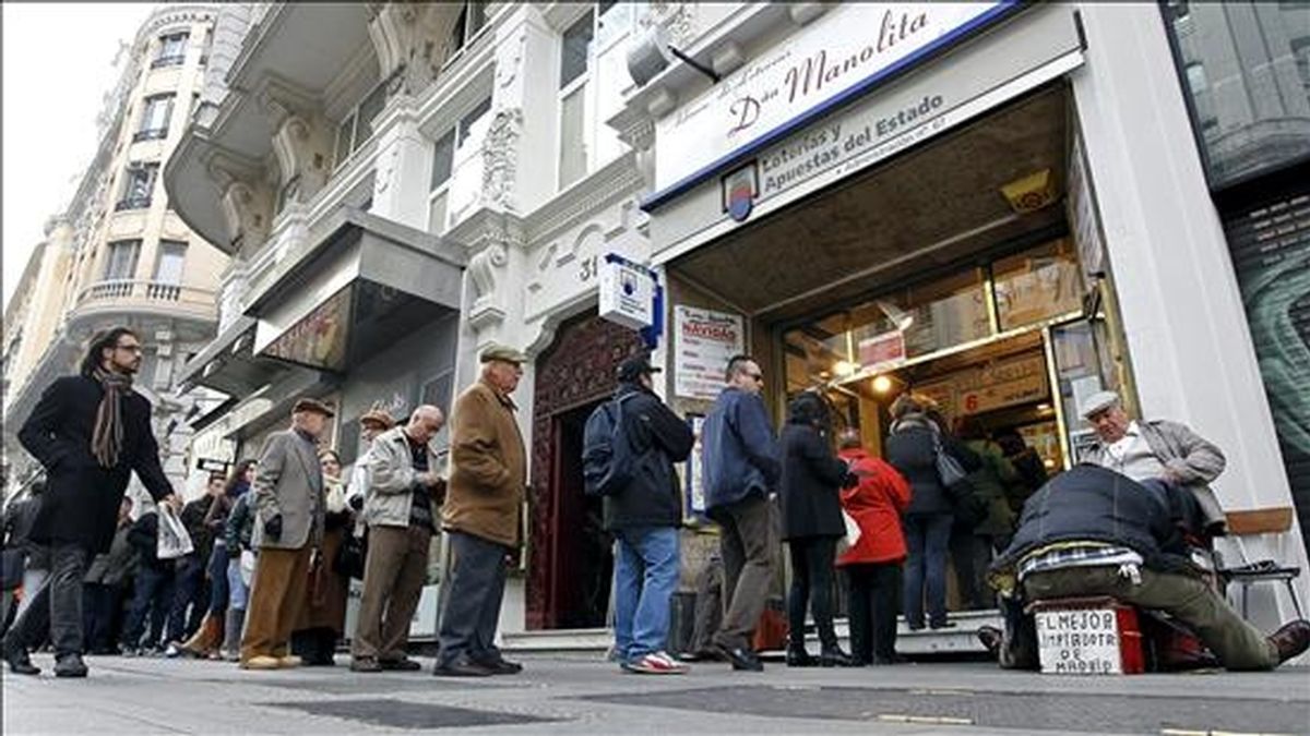 Decenas de personas aguardan su turno para adquirir lotería de Navidad en la administración Doña Manolita, en la Gran Vía madrileña. EFE/Archivo