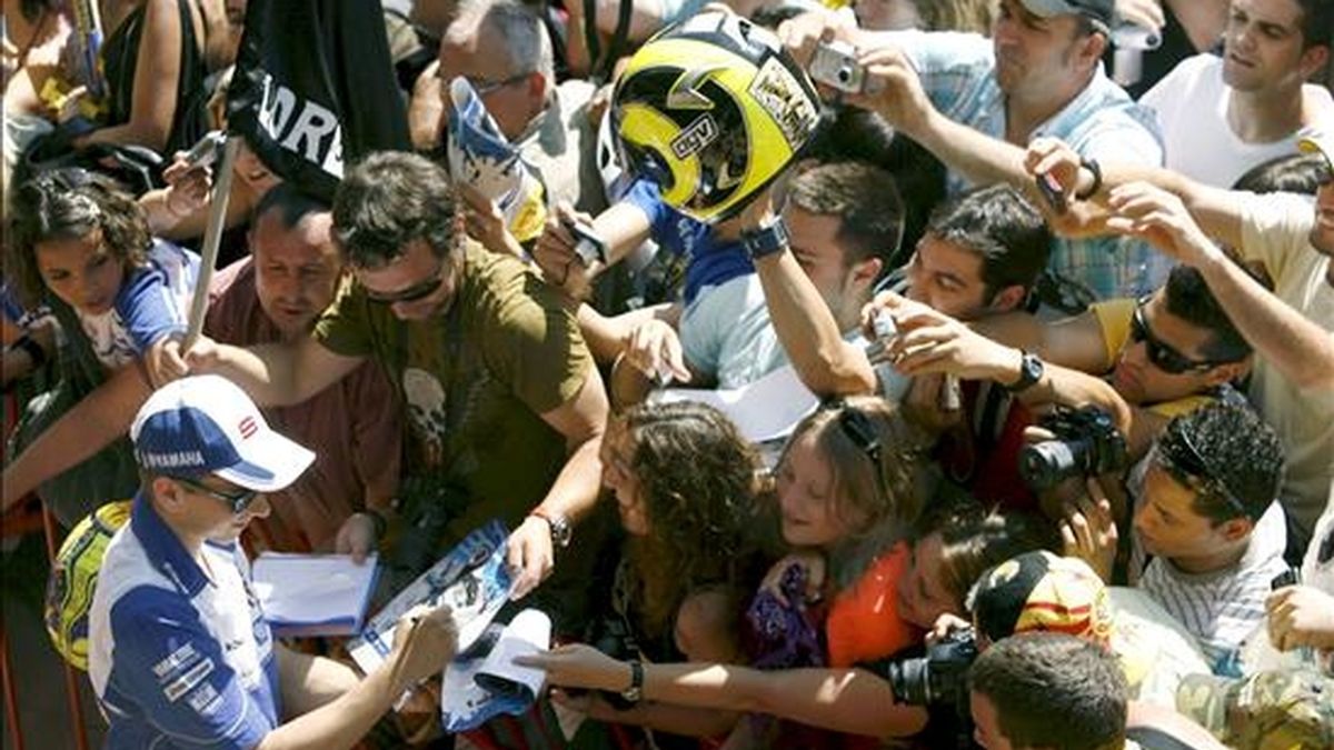 El piloto español de MotoGP Jorge Lorenzo (Fiat-Yamaha) firma autógrafos a sus fans durante la jornada de puertas abiertas en el Circuito de Montmeló (Barcelona), donde el próximo domingo se celebra el Gran Premio de Catalunya de motociclismo. EFE