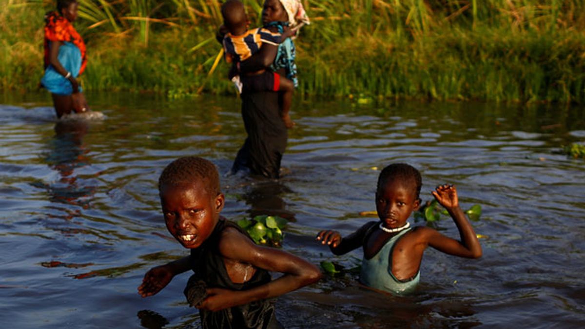 Niños en Sudán el Sur, cruzan el río para llegar al registro de suministro de comida de la ONU
