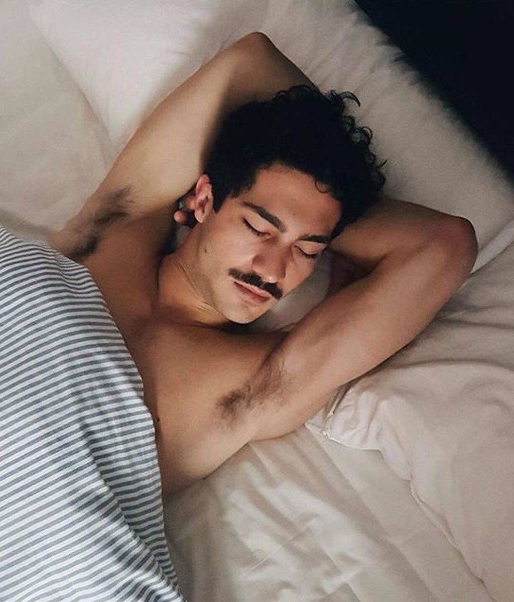 Haciéndose el dormido posa Chino Darín entre sábanas