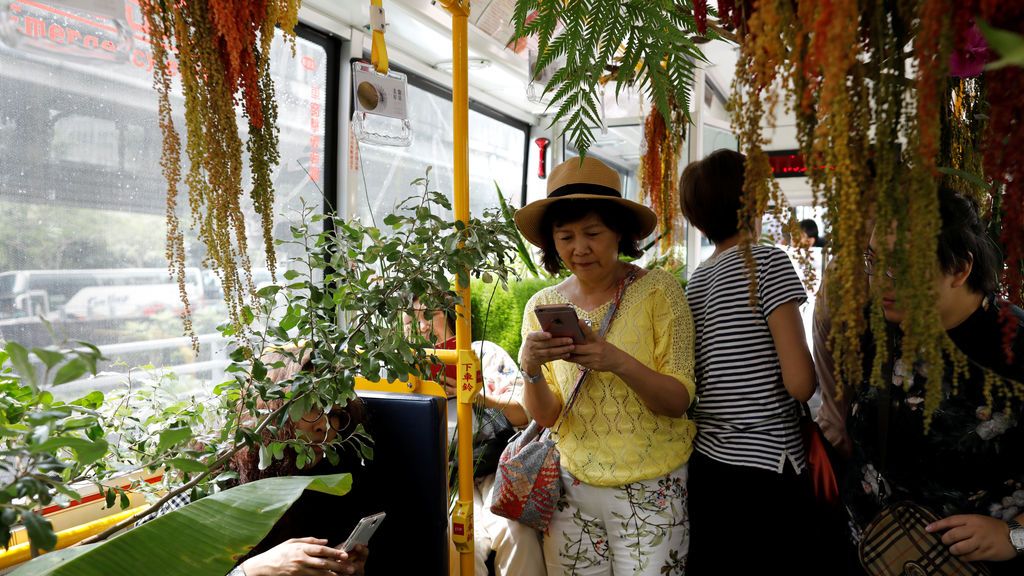 Pasajeros en un autobús lleno de vegetación