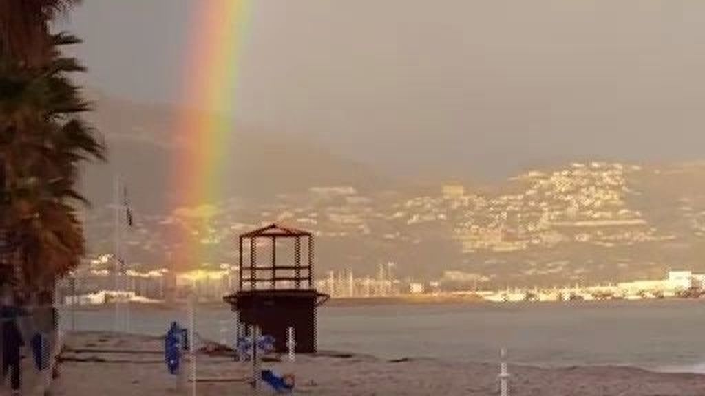 Un arcoíris perfecto se deja ver en Altea e inunda su playa de colores vivos