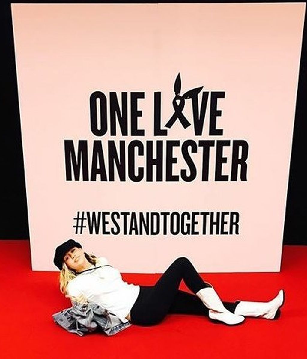 Miley Cyrus posando junto al cartel promocional minutos antes de su actuación