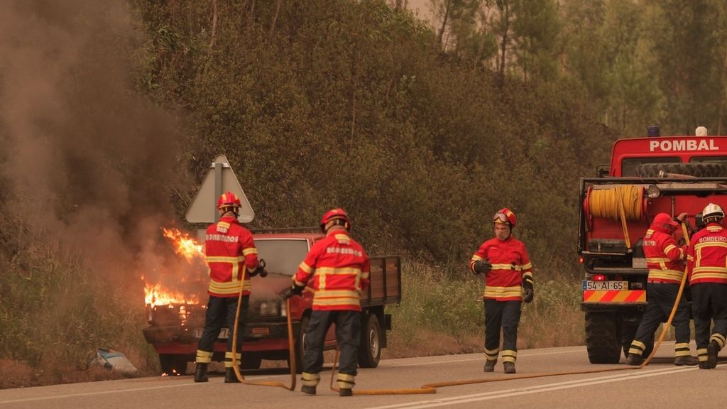 Bomberos intenta apagar las llamas de un coche ardiendo