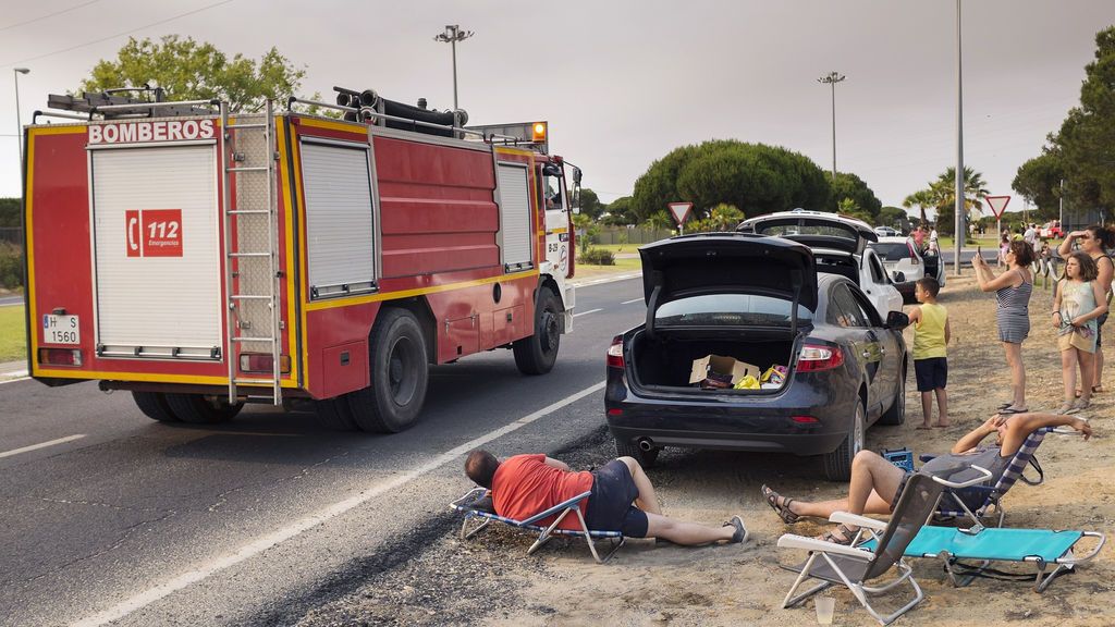 Varios turistas esperan a que abran la carreteras de salida desde Matalascañas, cortadas por el incendio de Moguer que se extiende por Doñana, para volver a sus casas.