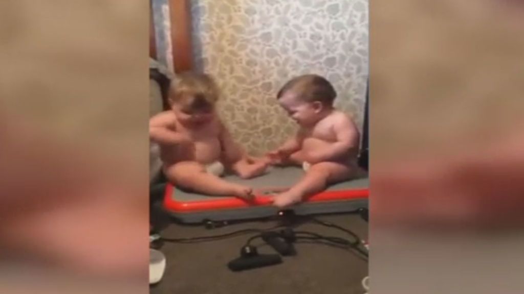 Dos bebés, muertos de risa con el movimiento de su cuerpo sobre una plataforma vibradora