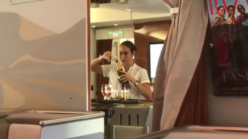 ¿Está esta azafata rellenando una botella con las sobras de una copa?