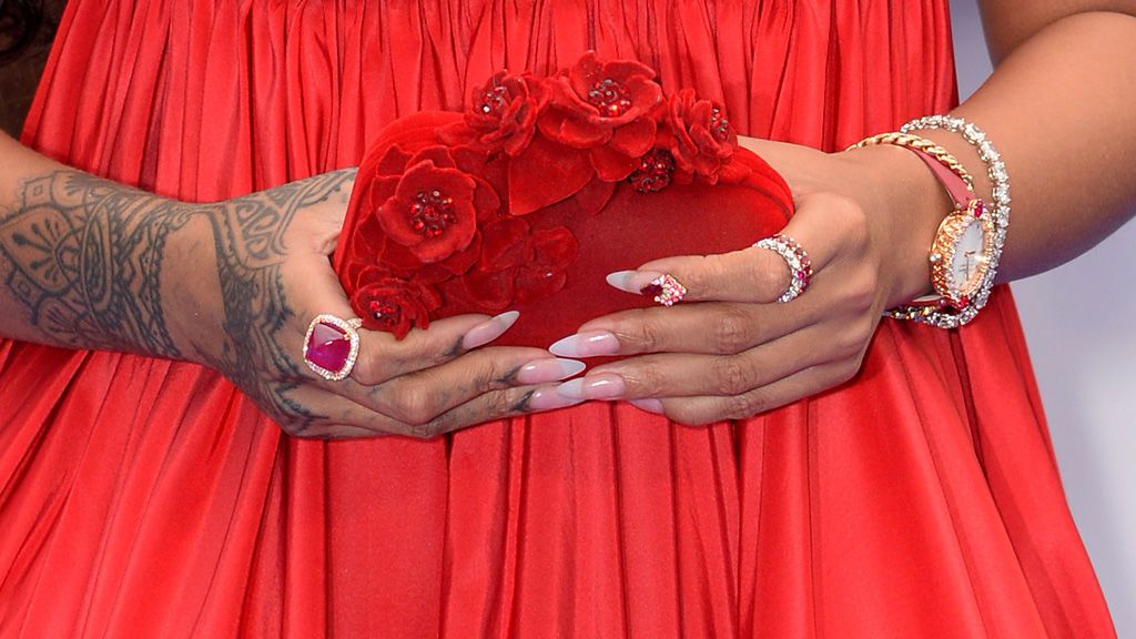 El bolso, un clutch Jimmy Choo también en rojo con detalles de rosetones