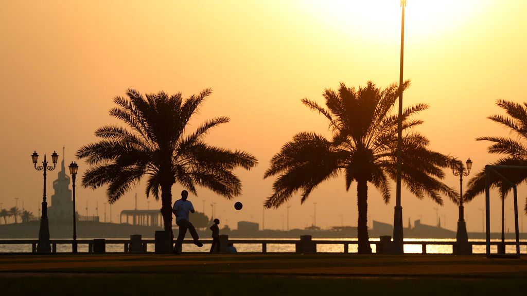 Un hombre juega al fútbol durante el atardecer en Dammam, Arabia Saudí