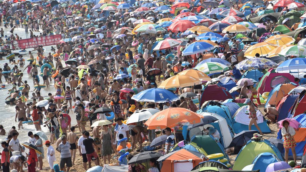 Una multitud de personas invaden la orilla de la playa cerca de un resort en China