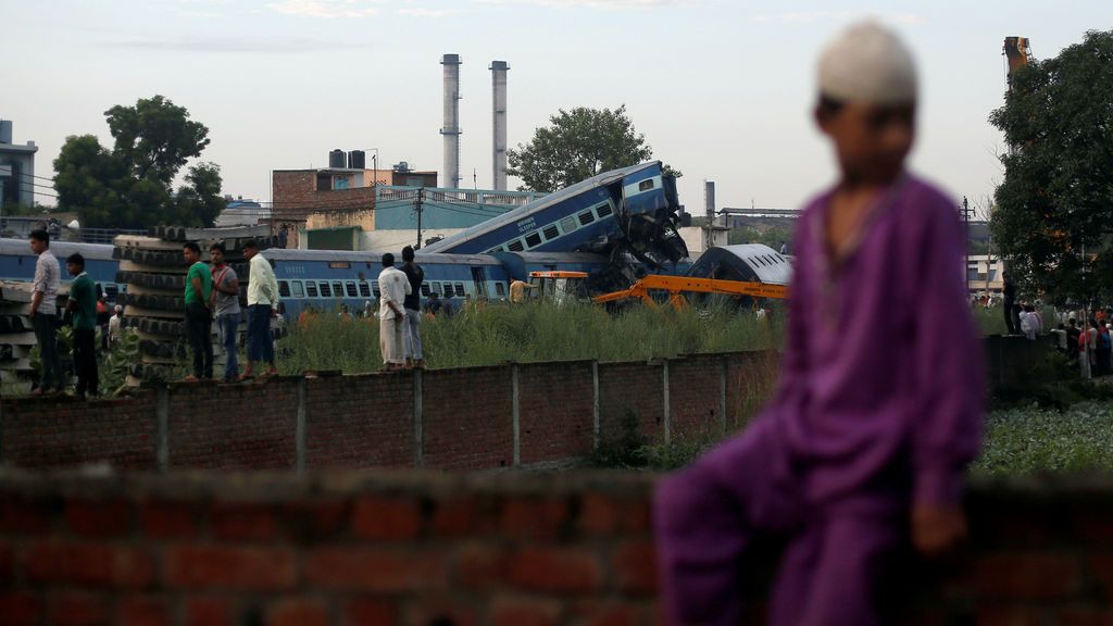 Niño sentado cerca del descarrilamiento de un tren en India