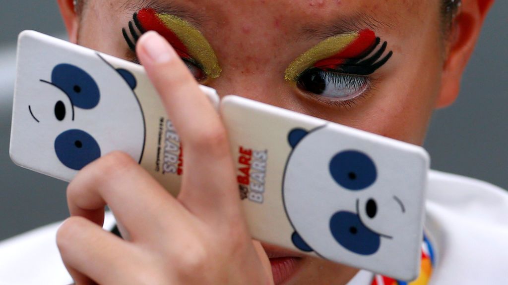 Una competidora de los juegos finales de Natación Sincronizada retocándose el maquillaje
