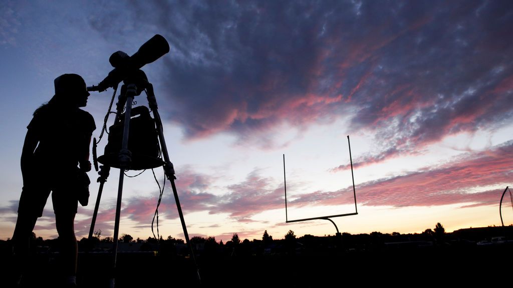 Una mujer mira por el telescopio antes de que se produzca el eclipse solar en Mandras