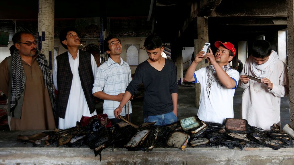 Varios hombres inspeccionan libros del Corán quemados en una mezquita después del ataque en Kabul