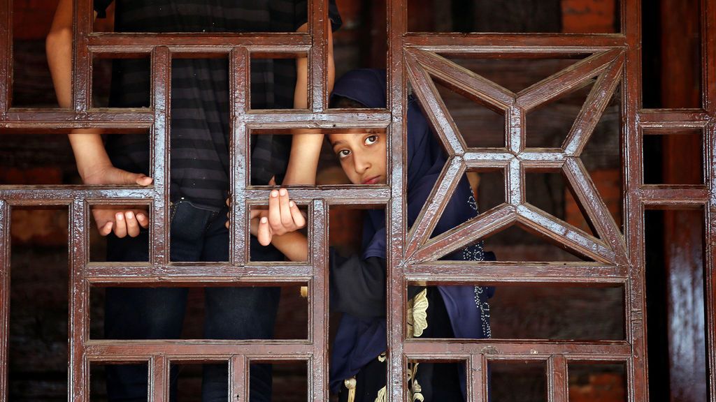 Una niña musulmana mira a través de una ventana durante un festival religioso en Srinagar