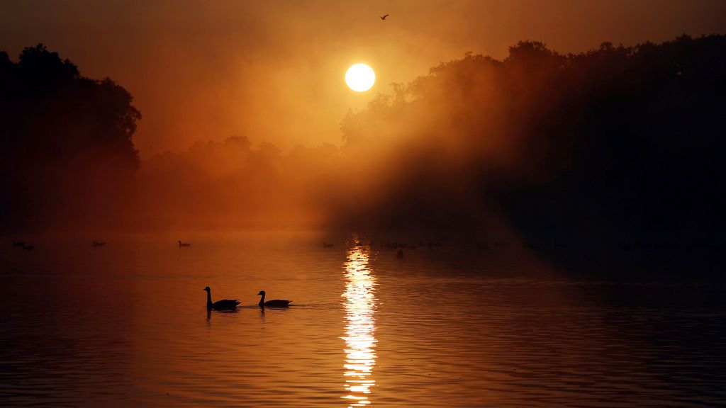 El sol se pone sobre el estanque redondo en los jardines de Kensington en Londres