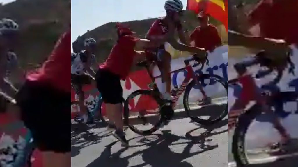Un aficionado tira al suelo de un empujón a un ciclista en plena carrera de La Vuelta