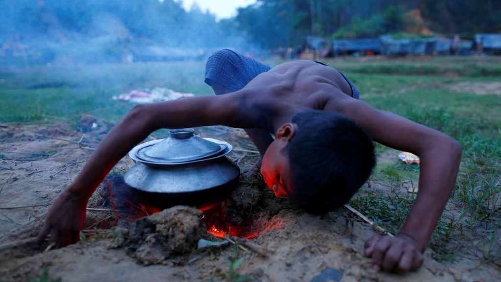 Un refugiado Rohingya enciende fuego para cocinar en su albergue temporal en Bangladesh