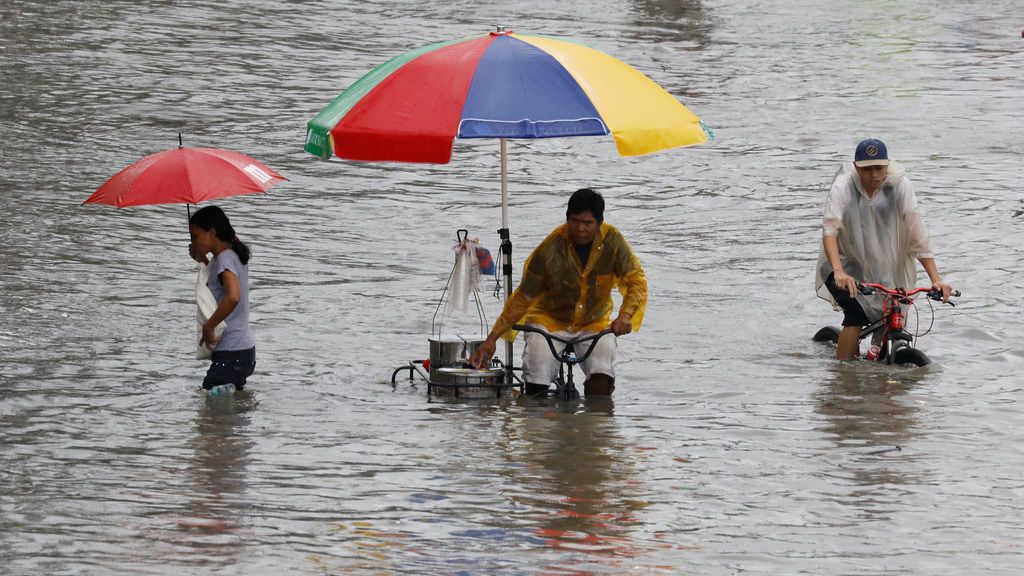 Ciudadanos filipinos circulan por las calles inundadas de Las Pinas, Filipinas