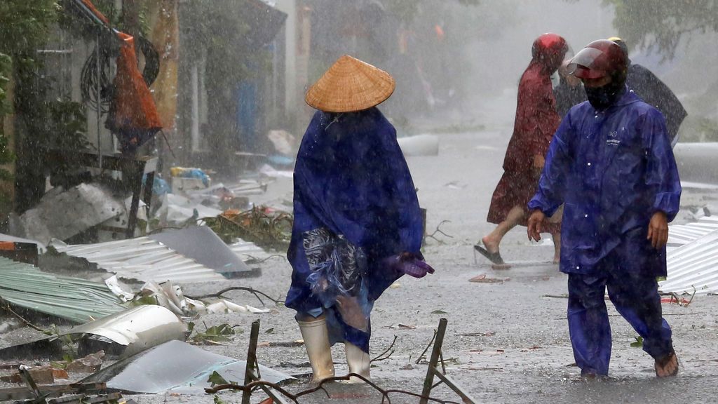 Dos ciudadanos ayudan a limpiar las calles después de la tormenta Doksuri