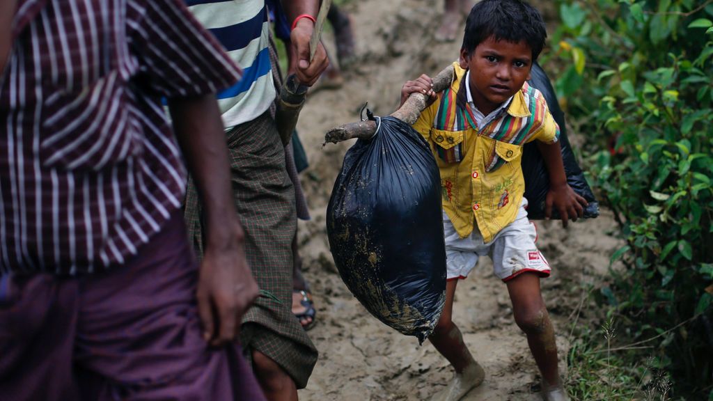 Un niño refugiado Rohingya lleva consigo sus pertenencias a la vez que camina al campo donde va a vivir en Cox’s Bazar
