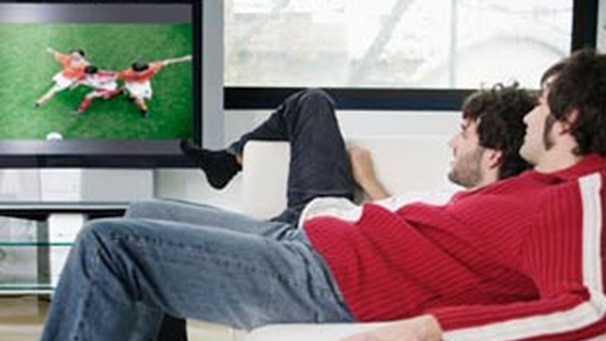 Unos jóvenes ven deportes en televisión.