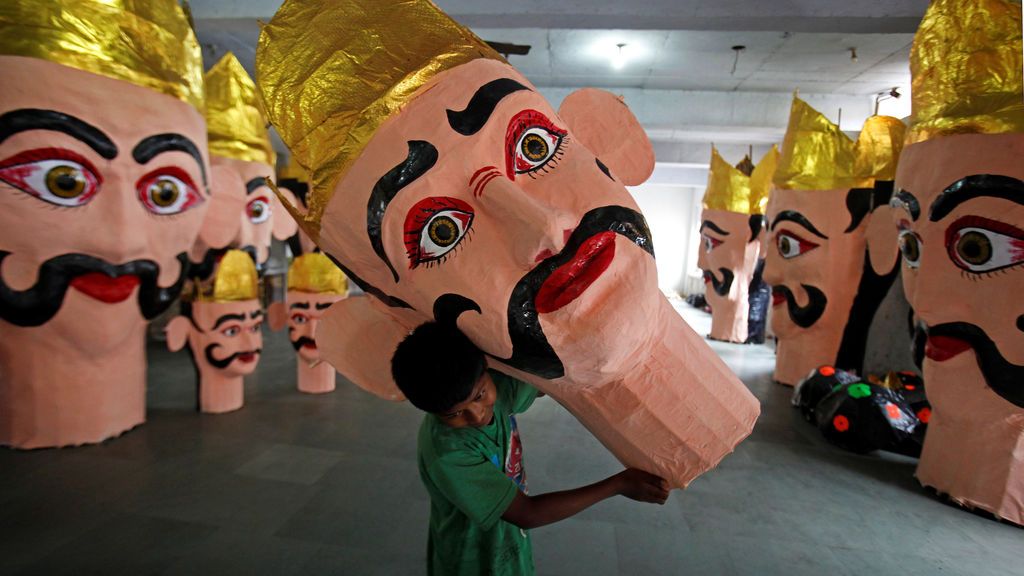 Un niño, mueve la cabeza de la esfinge Ravana durante las preparaciones del festival indú Dussehra