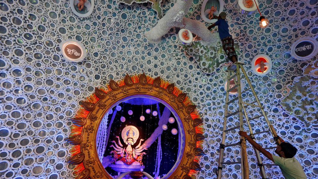 Un electricista examina las luces decorativas de un panal preparado para el festival hindú de Durga, India
