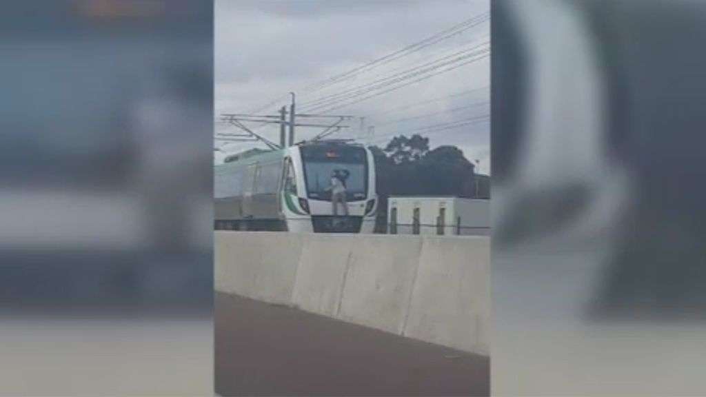 Un hombre viaja sujeto al limpiaparabrisas de la parte trasera de un tren