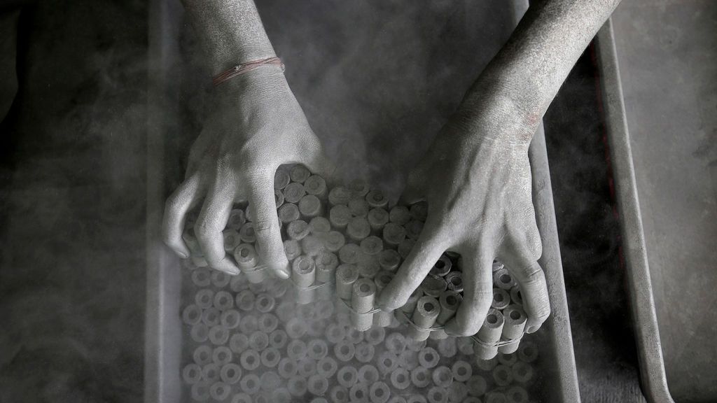 Un trabajador retira rollos de papel después de llenarlos con la mezcla de pólvora