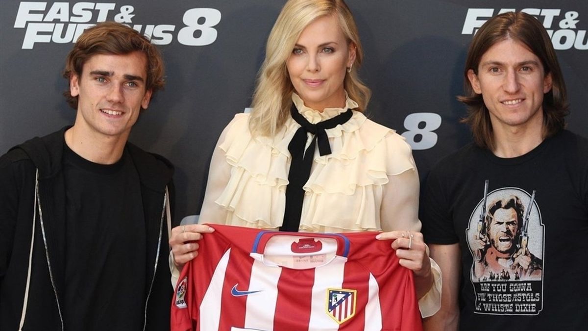 Charlize Theron, junto con los jugadores del Atlético de Madrid Griezman y Filipe Louis.