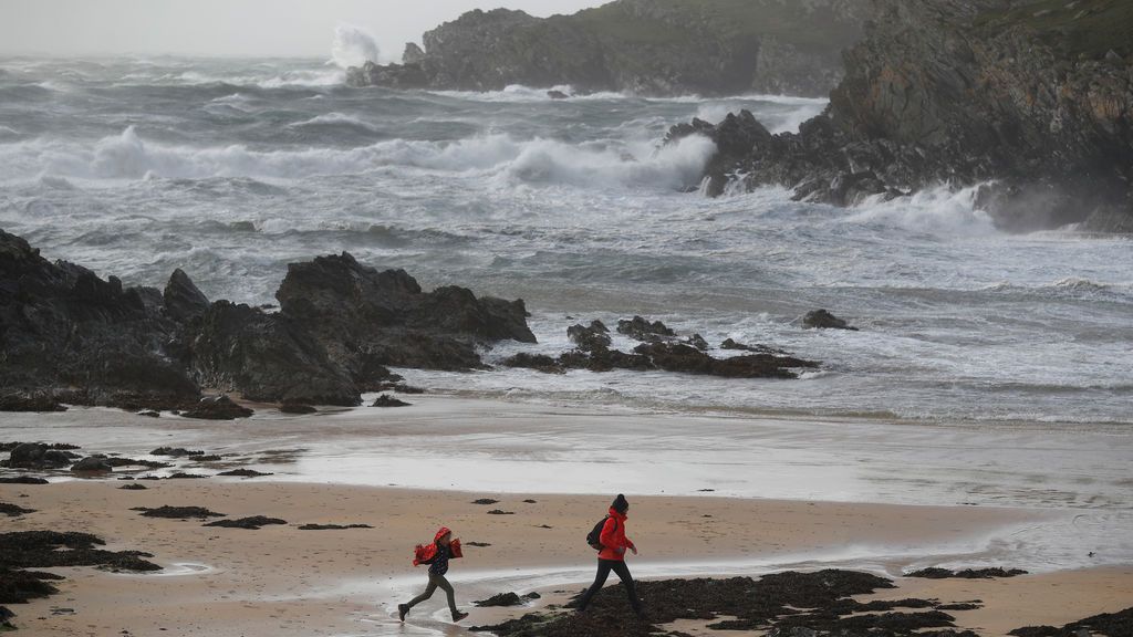 Dos personas caminan por una playa a la que se aproxima Ophelia